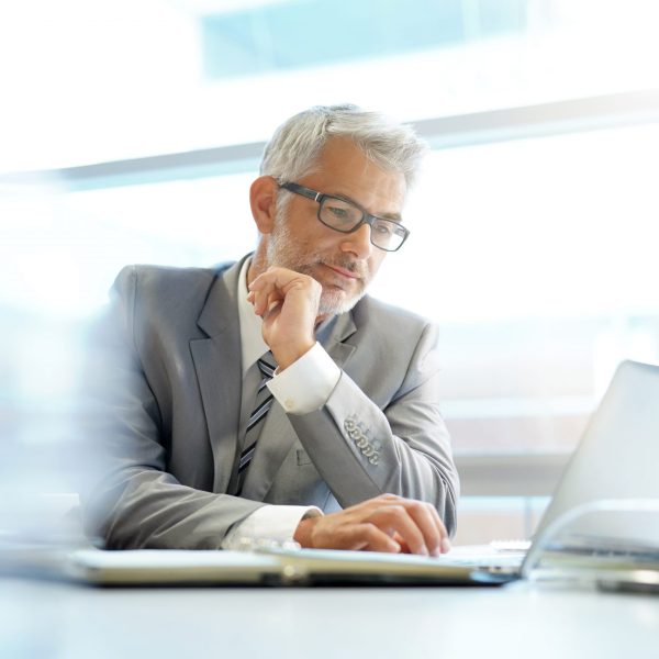 Stylish businessman working at desk in contemporary office